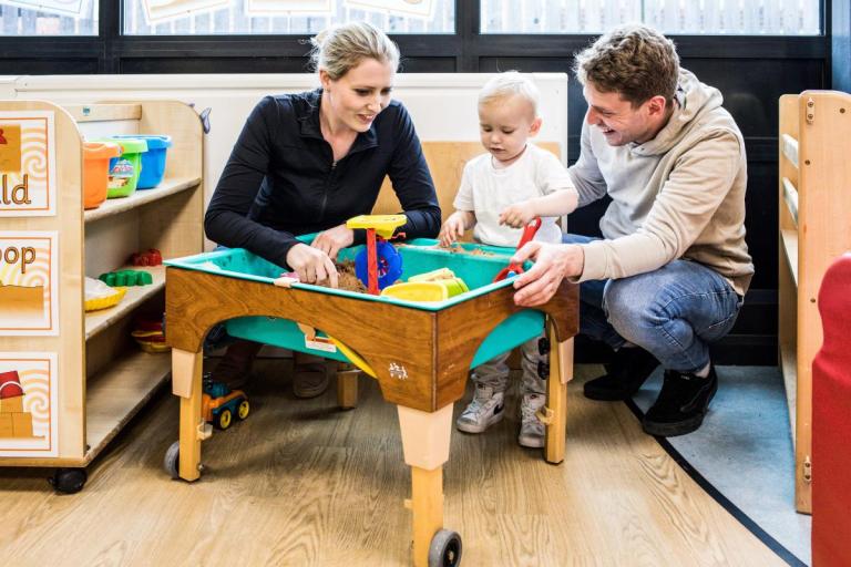 Parents and child playing in the sand