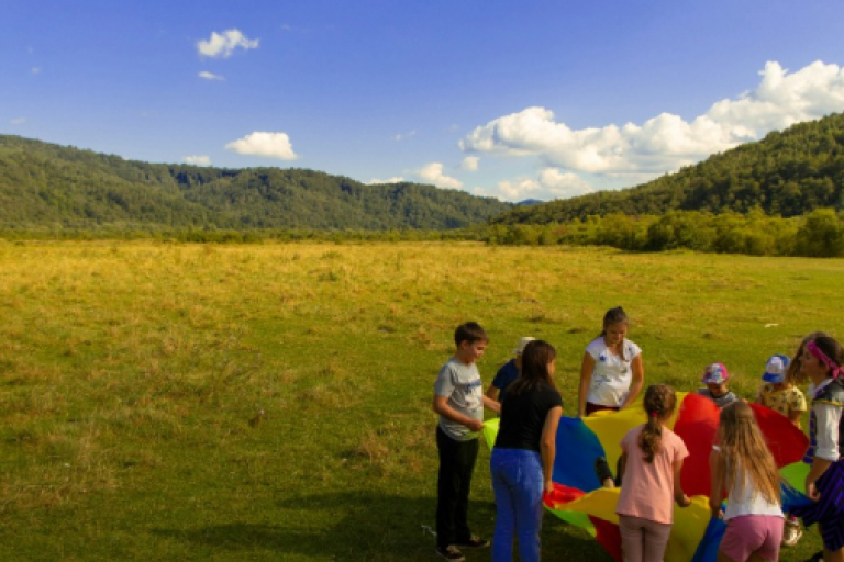 Kids playing with parachute in field